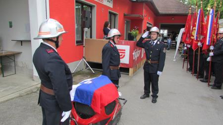 Poveljnik Peter Ficko predaja motorno brizgalno svojemu namenu. 